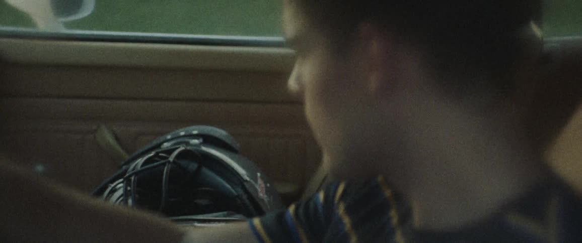 A man looks at an object sitting on the passenger seat of his car