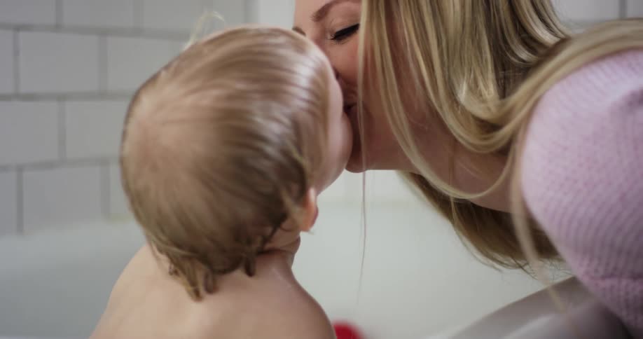 A mother bathes her young child