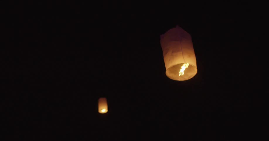 Paper lanterns floating in the night sky