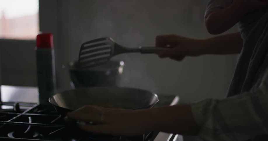 A person is cooking on a pan in the kitchen