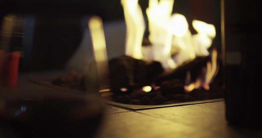 Glass of red wine next to a fire