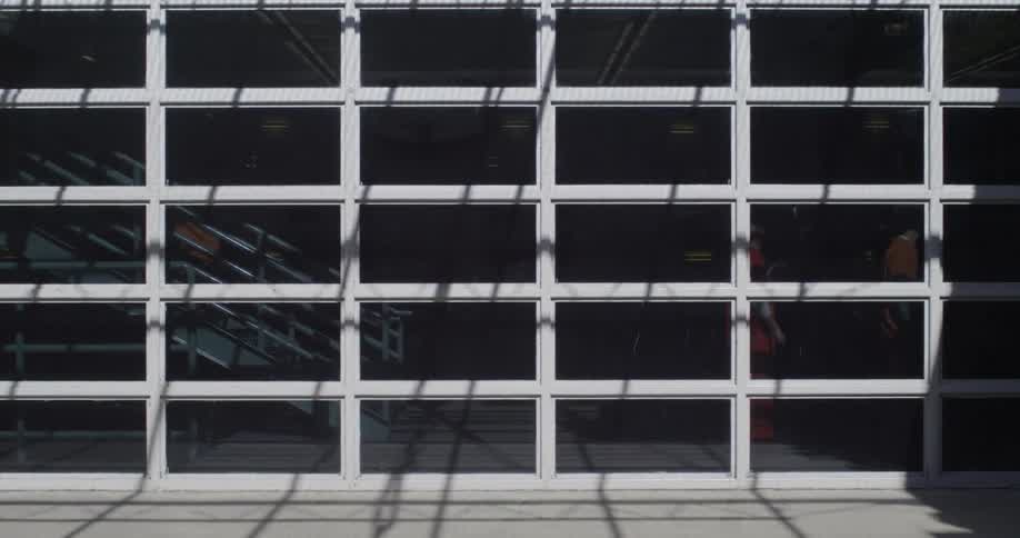 A building has many windows as a person climbs down the stairs inside
