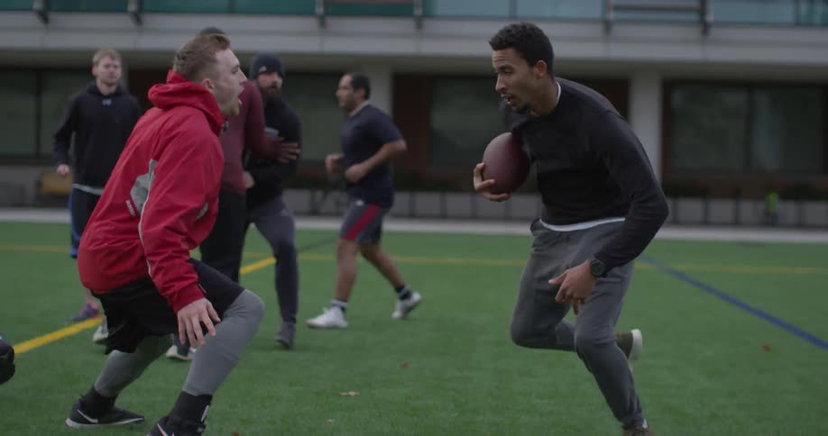 Men play football on an outdoor field