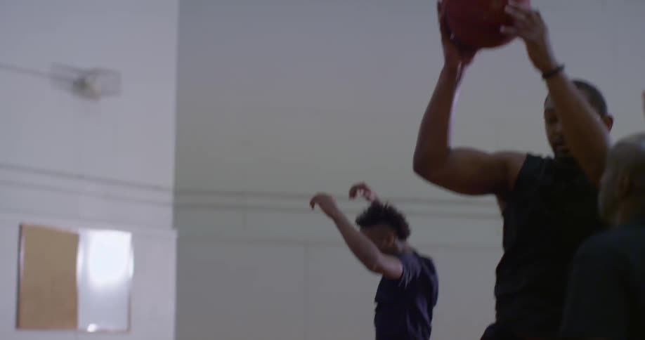 Men play basketball on an indoor court