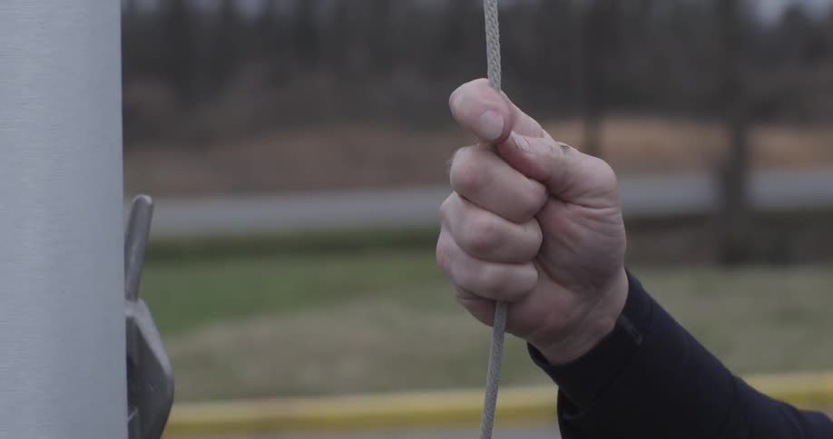 A person raising a flag on a pole