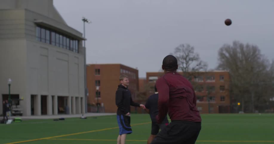 A man jumps and misses a football