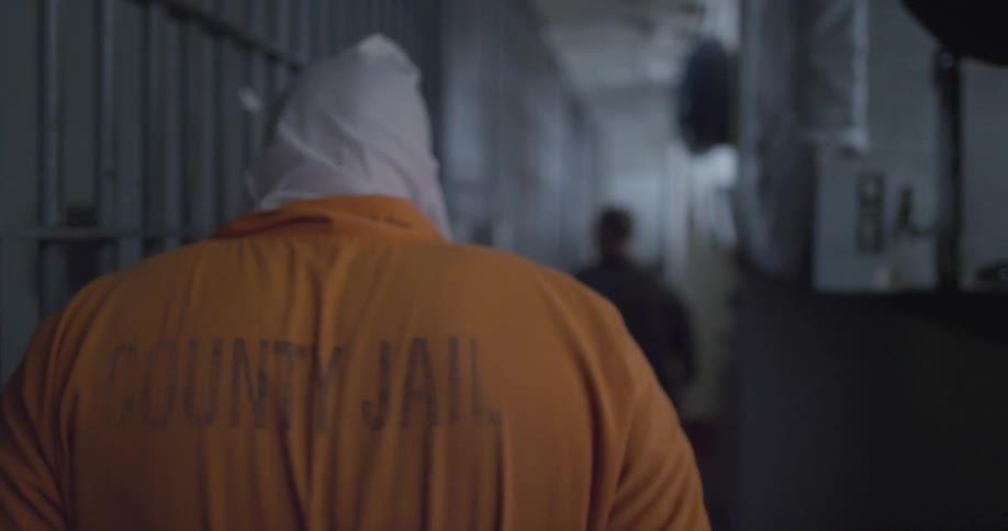 A prisoner walks through a jail