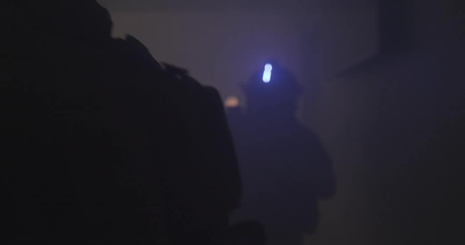 Soldiers move through a dark building