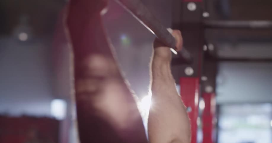 A man doing pull ups and then dropping from the bar