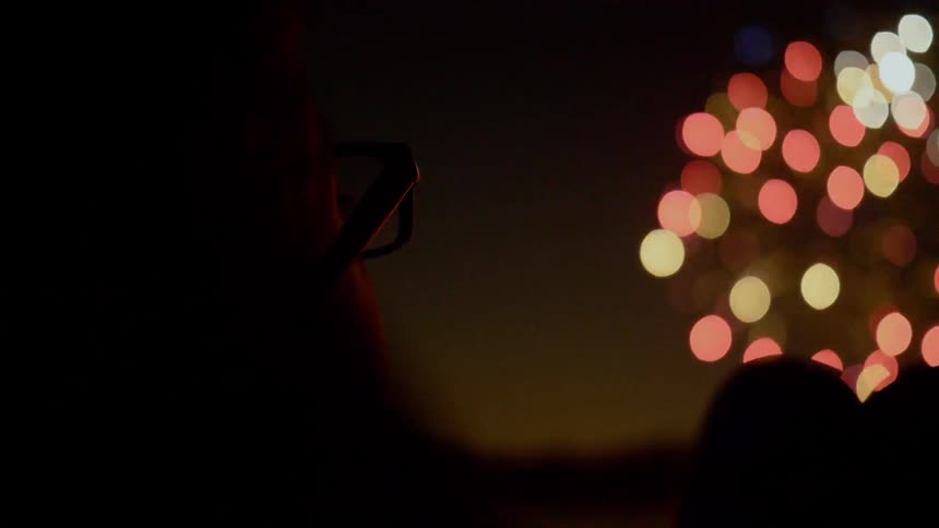 A man is watching fireworks outdoors