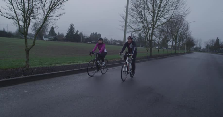 Two people are riding their bikes on a cloudy day