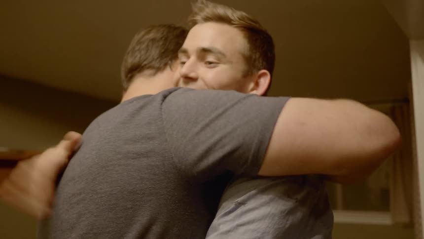 A pair of men greeting each other with a hug