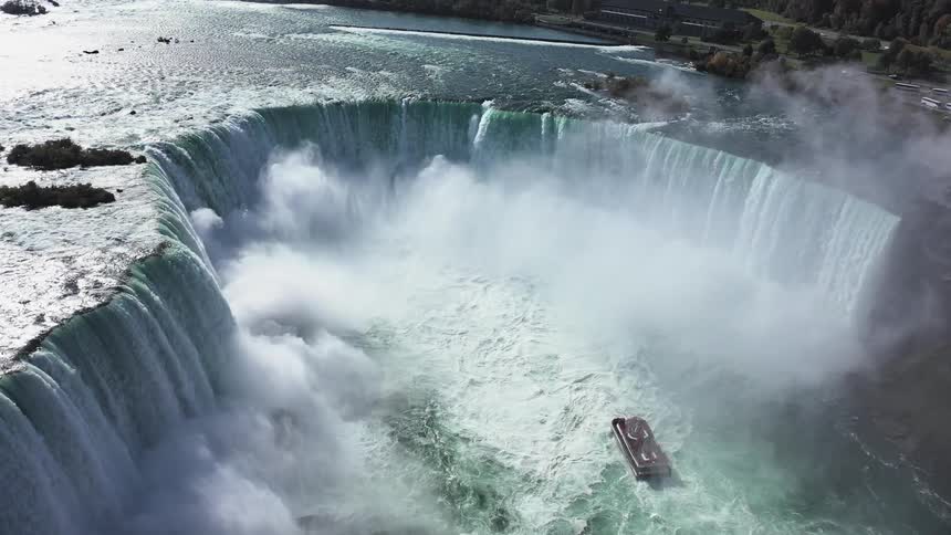 The boat sails towards the waterfall