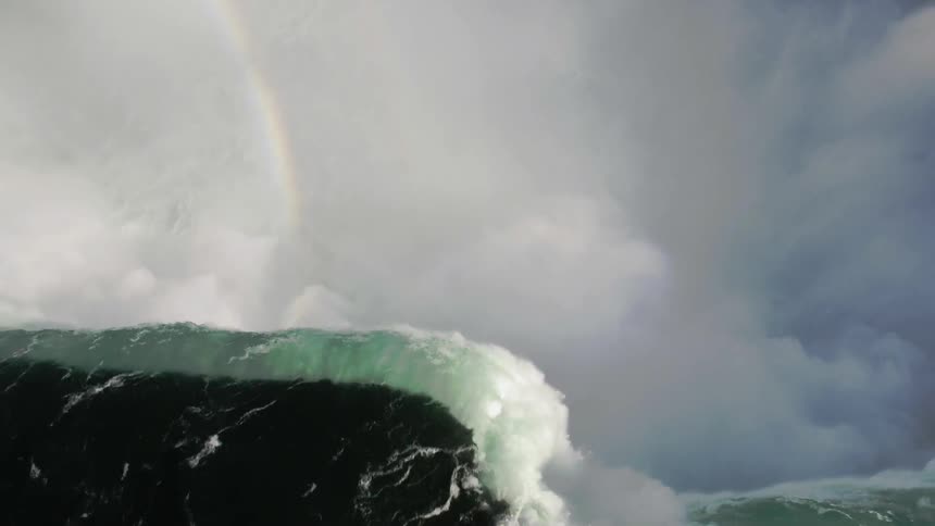 An aerial view of a waterfall rainbow and haze