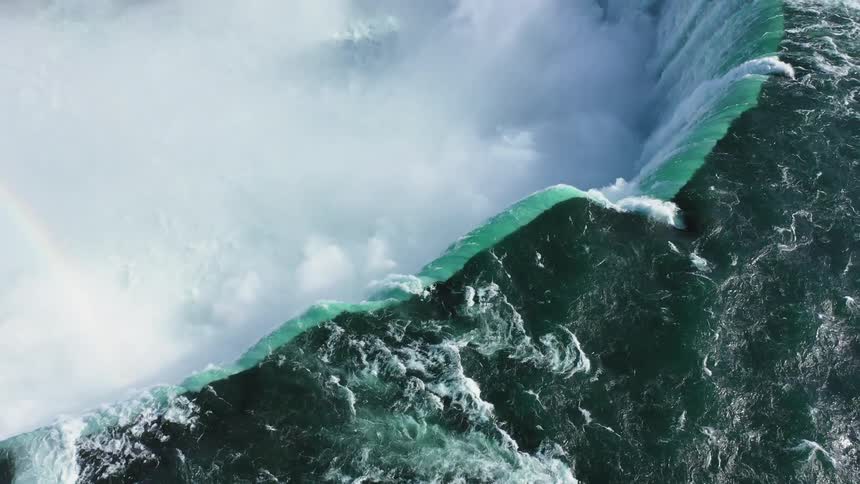 Water falls over massive circular shaped waterfall