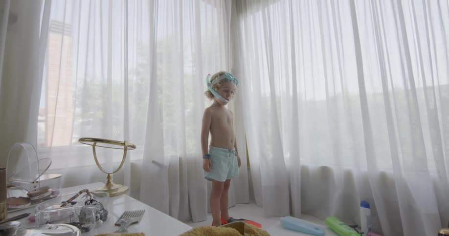 A boy standing with swimming gear