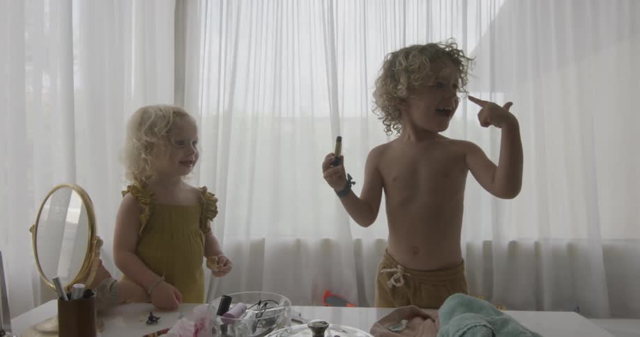 Two young children play together with makeup