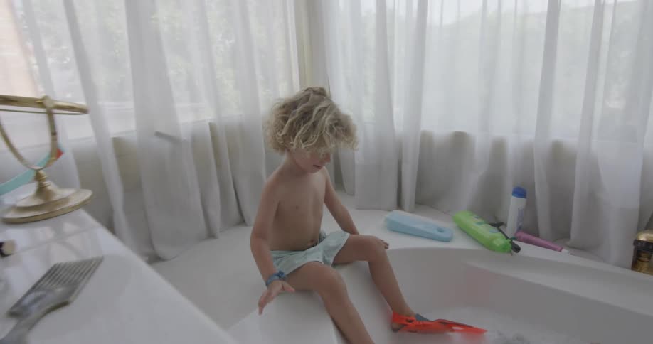 Young child playing in a tub