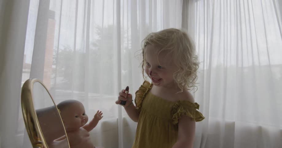 Toddler playing with makeup in front of mirror