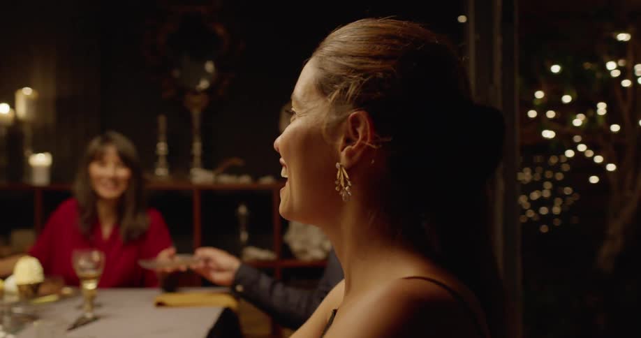 A group of women chatting and laughing while sitting around a dinner table