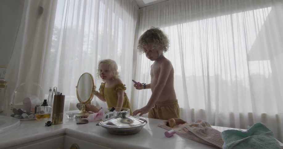 A boy and girl play and put make up all over their faces