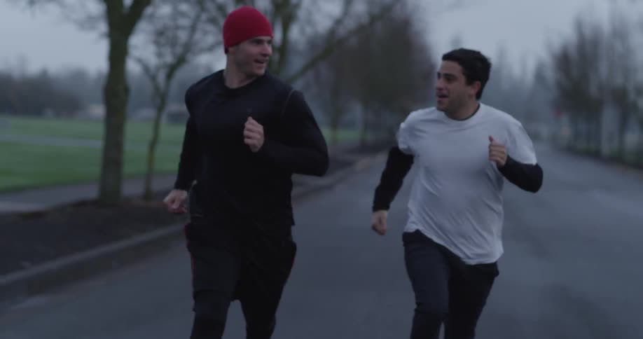 Two men are running outside on a cloudy day