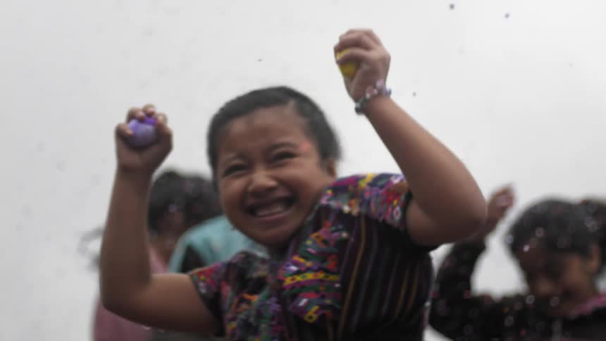 A child is playing outside with colored dirt being thrown around