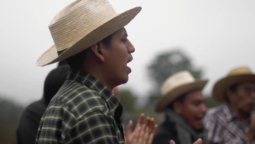 Men clap and cheer standing outdoors