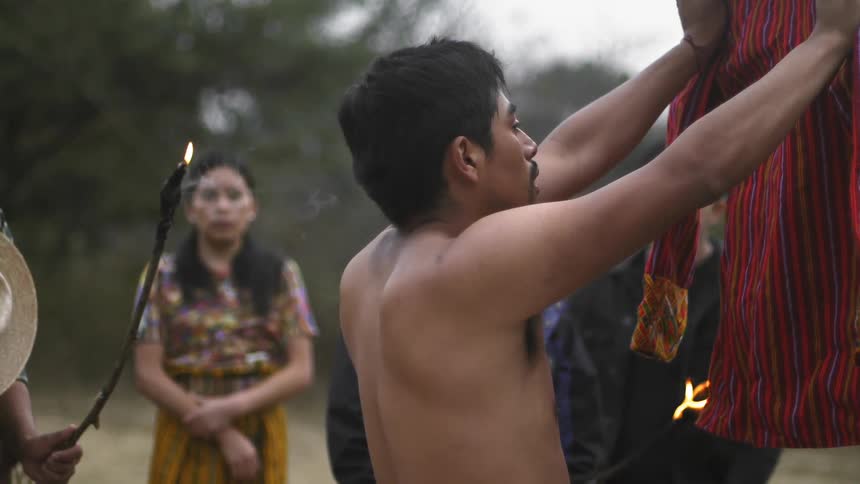A man holds up a coat during a ceremony