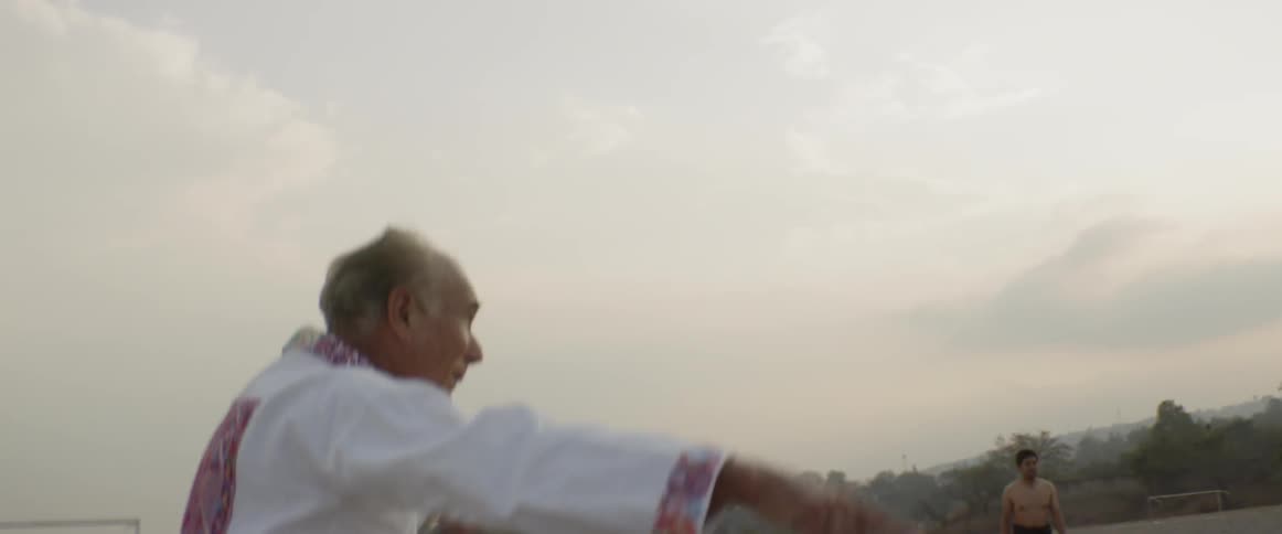 An old man rallies together people playing an outdoor sport