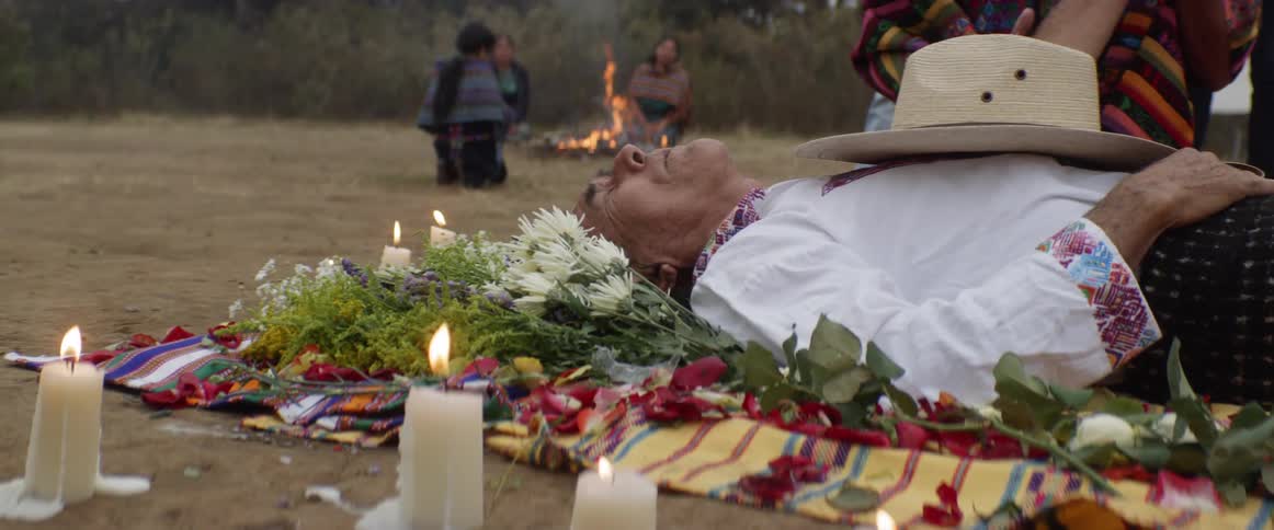 A person lays on the ground for a ceremony