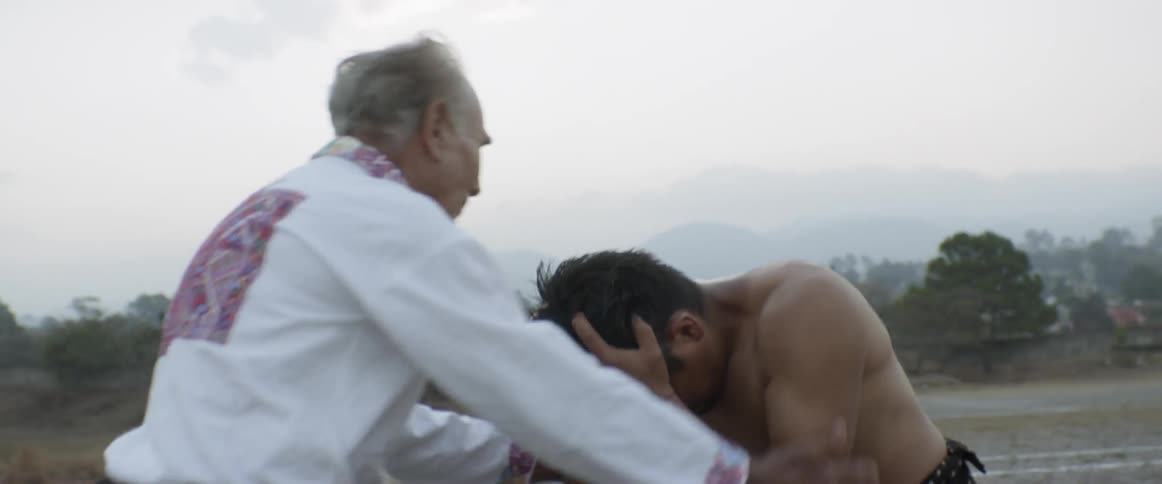 Man yelling in grief as an older man walks up to comfort him