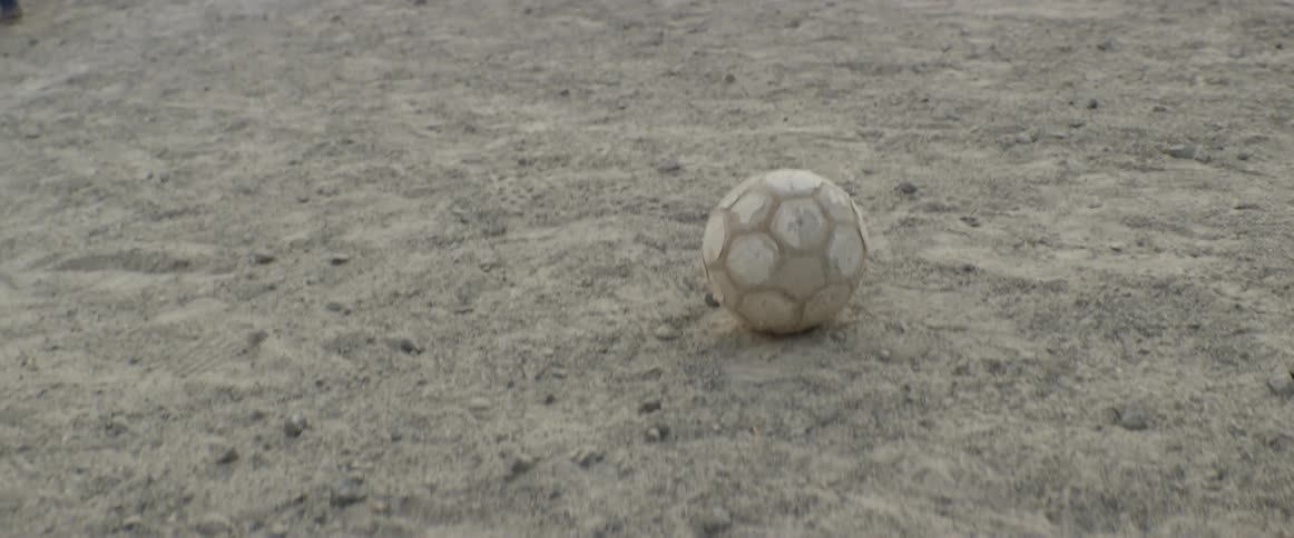 A footage of a white ball on a sand