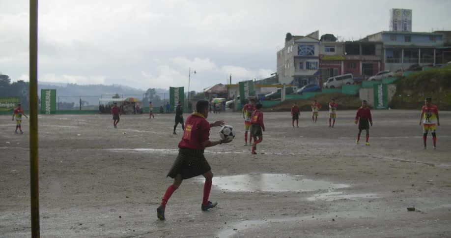A group of man play football on the field