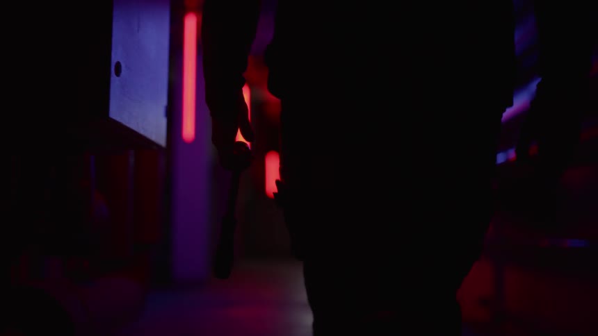 A man with a gun walking in the dark