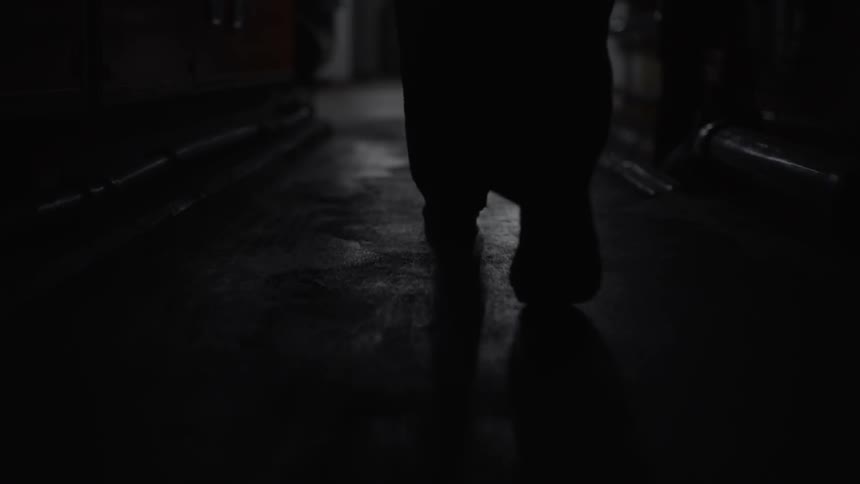 A person walks down a dark hallway