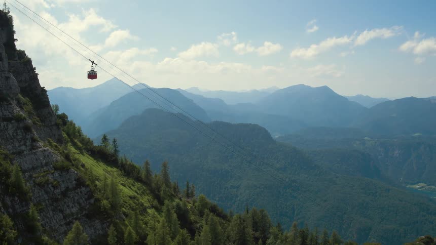A gondola travels over a mountain slope in the wilderness