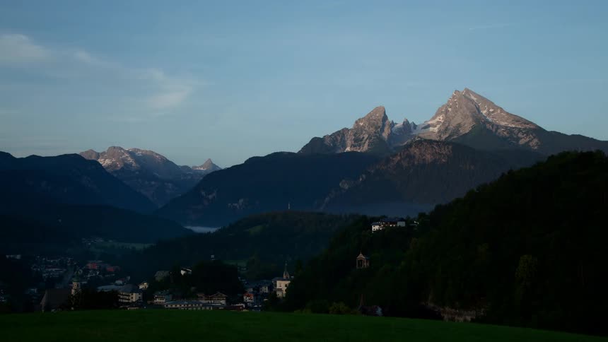 A town sits in the valley below the mountains