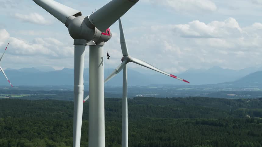 Wind turbines spin slowly above a large field