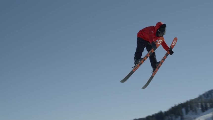 Skier jumps through the air in snowy mountains