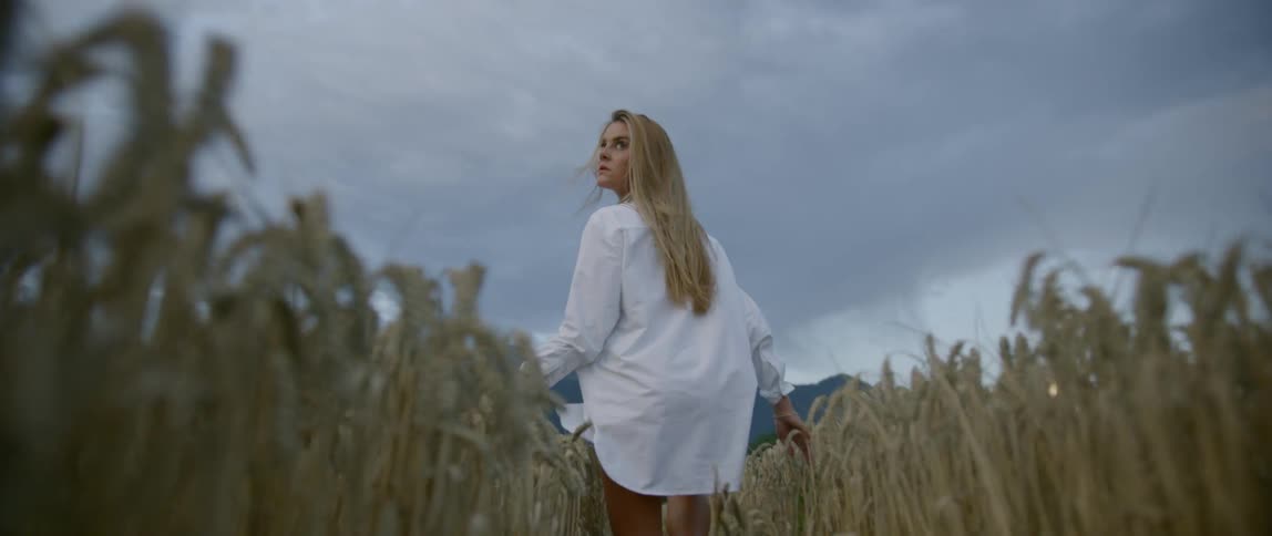 A blonde female running in the wheat field