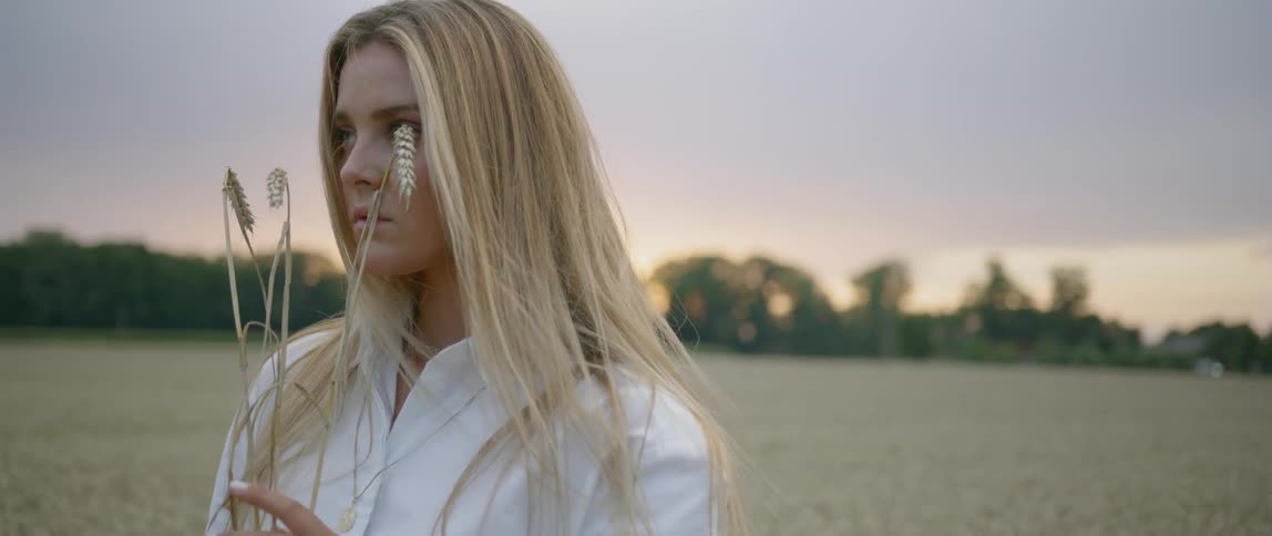 Woman holding wheat in a field