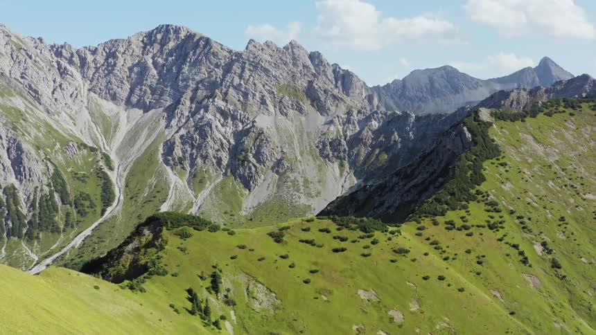 Green and rocky mountain ridges on a blue sky sunny day