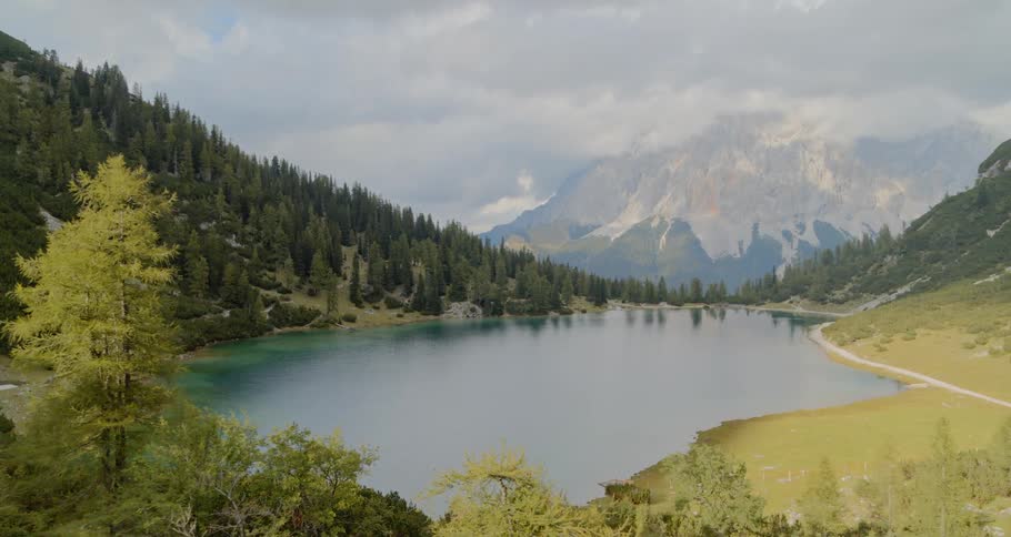 An aerial view of a lake surrounded by trees and mountains