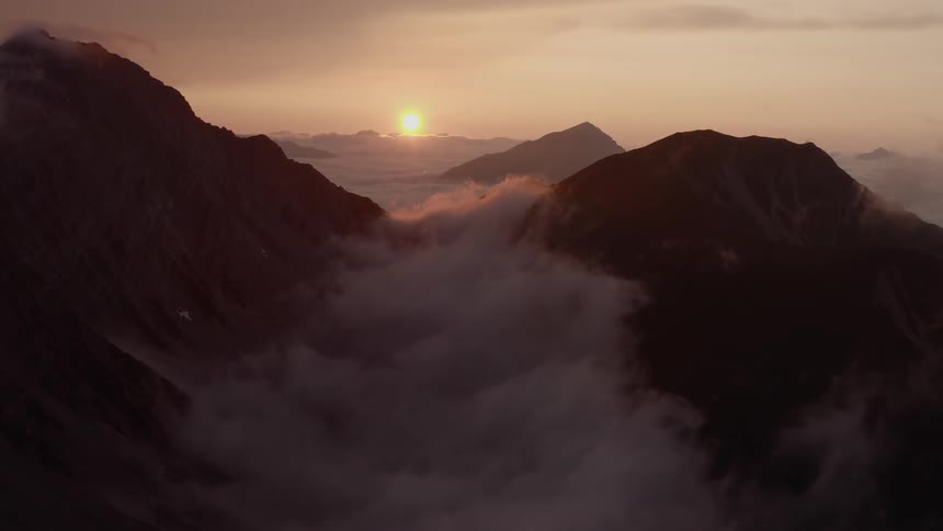 Landscape view of the sun setting behind the mountains