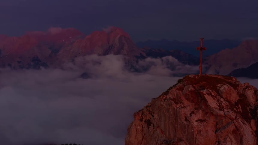 A cross sits on top of a cliff