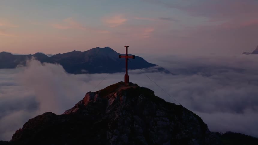 A cross sits on top of a cliff