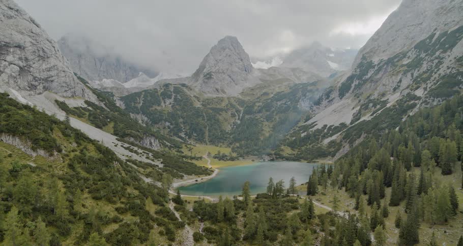 Snow covered mountains surrounding a lake and forest