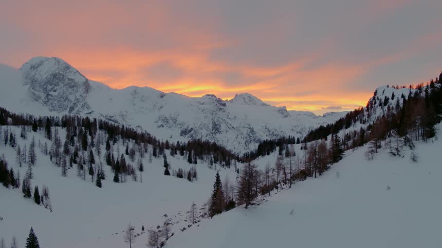 An aerial view of a snowy mountain at dawn