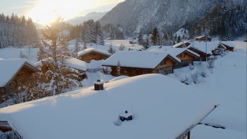 A group of mountain cabins covered by snow